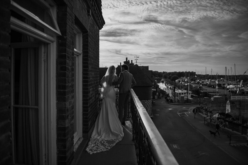 Couple cuddling on the balcony of The Bell Hotel in Sandwich photographed by Fine Art Wedding Photographer