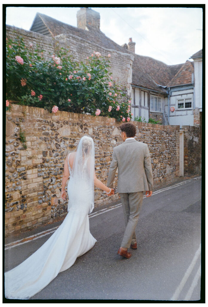 Fine art wedding photograph of bride and groom by pink roses