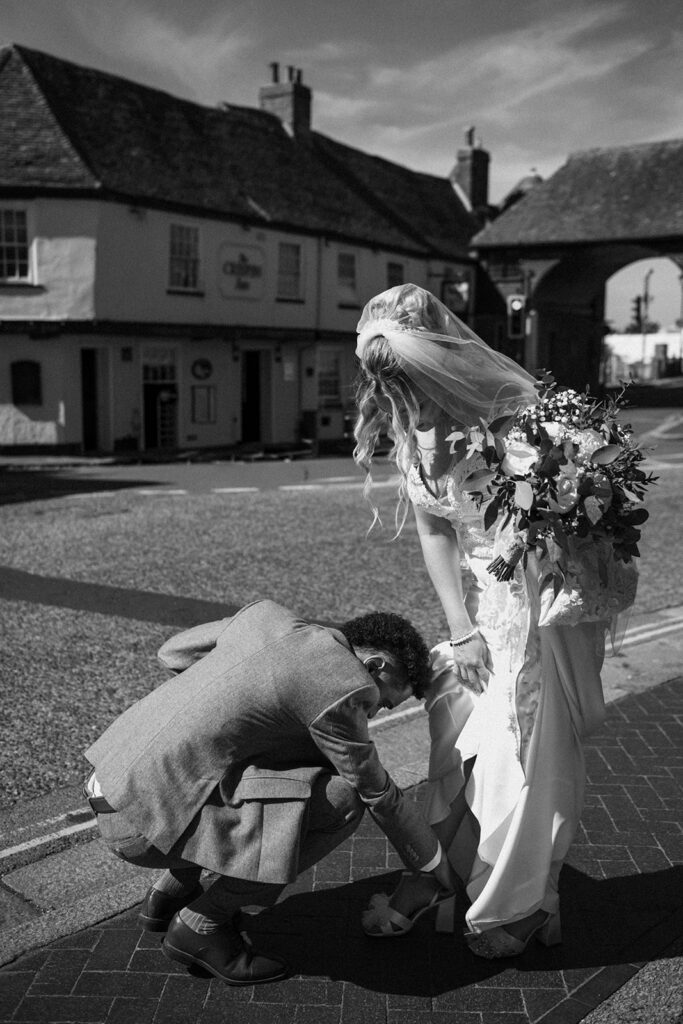 Groom adjusting brides shoes