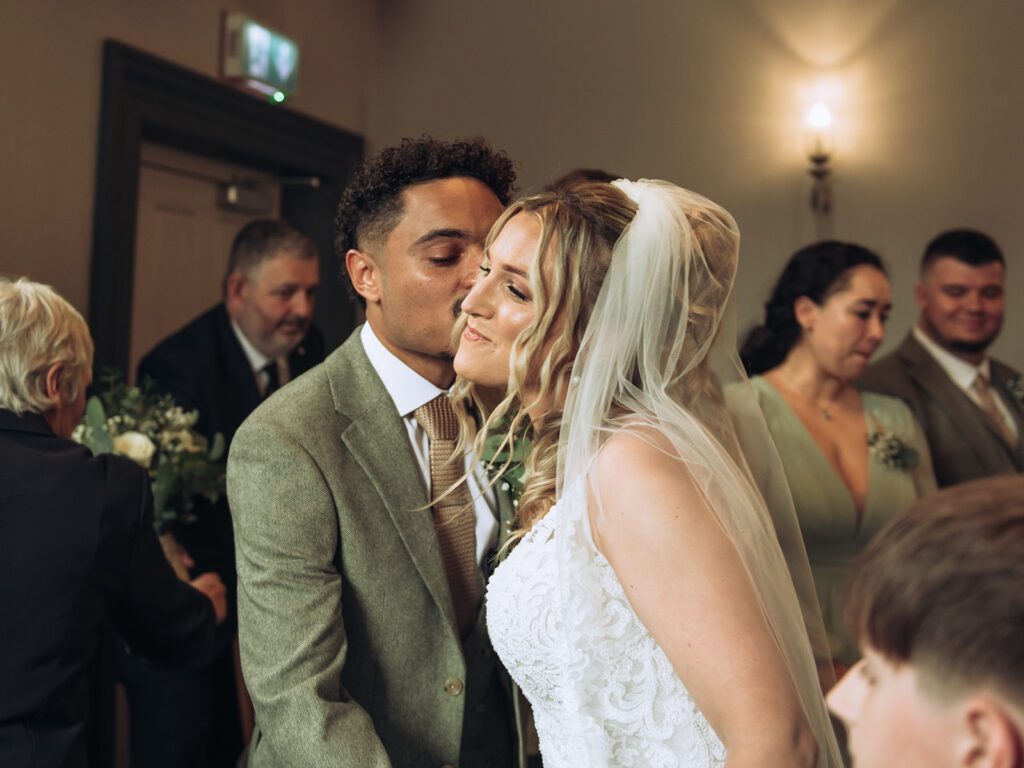 Groom kissing bride on cheek