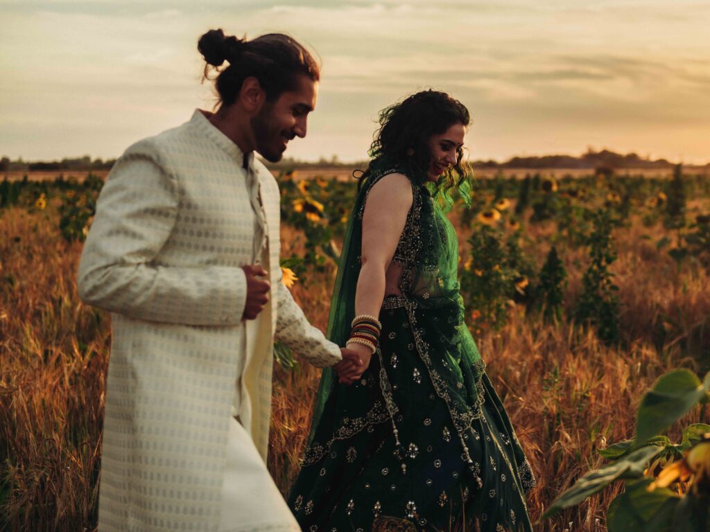 Bride and groom holding hands in sunflower field