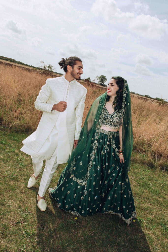 Bride and groom walking through a field at their luxury micro wedding