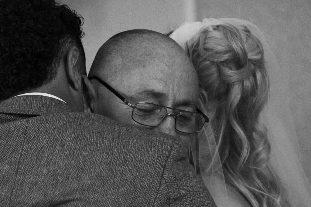 Man cuddling newlyweds