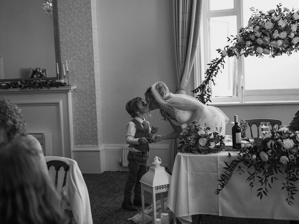 mother kissing son at wedding