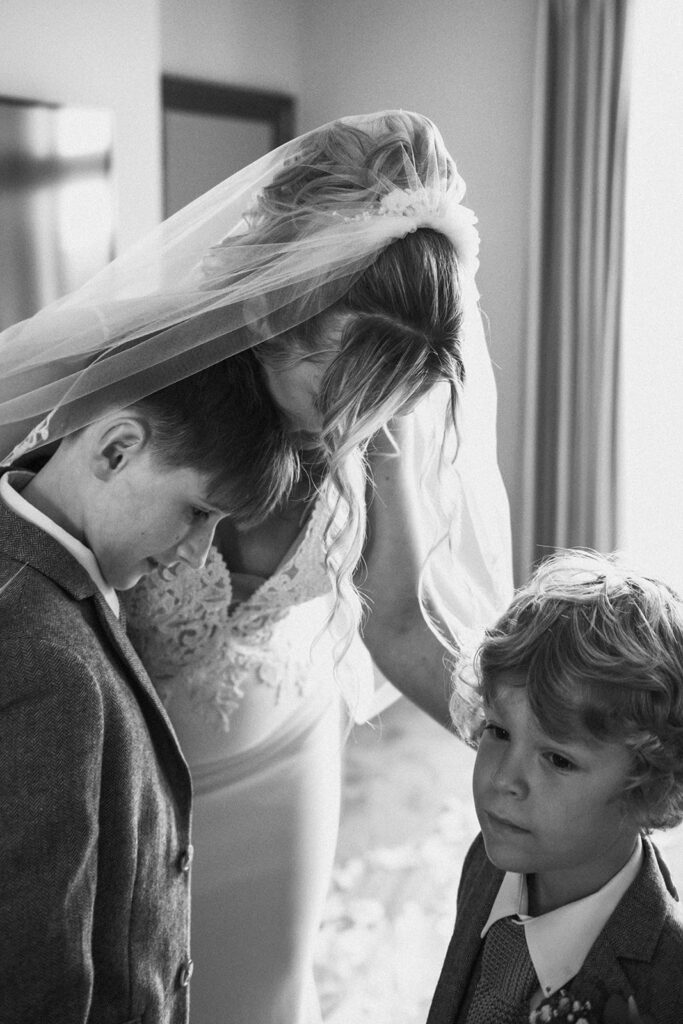 mother cuddling sons on wedding day