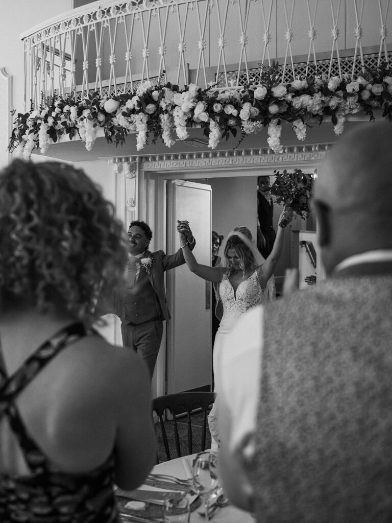 newlyweds walking into wedding reception