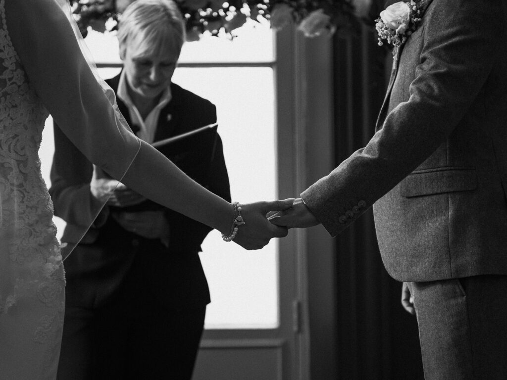 Bride and groom holding hands during wedding ceremony