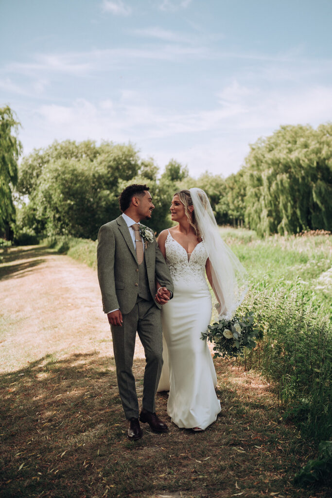 Bride and groom walking together by quay