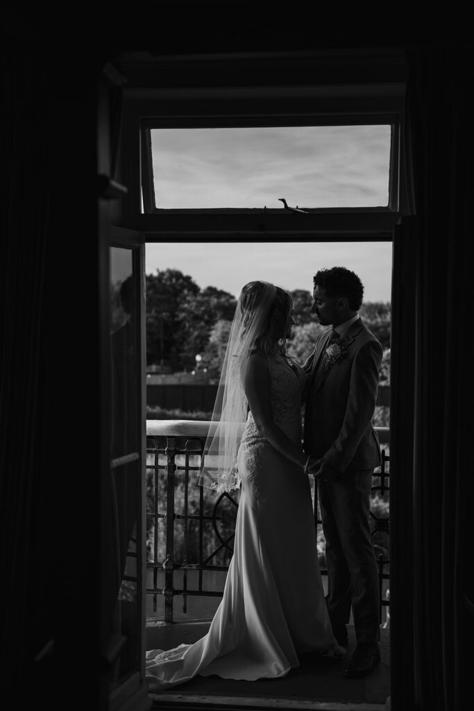 Newlyweds on balcony cuddling