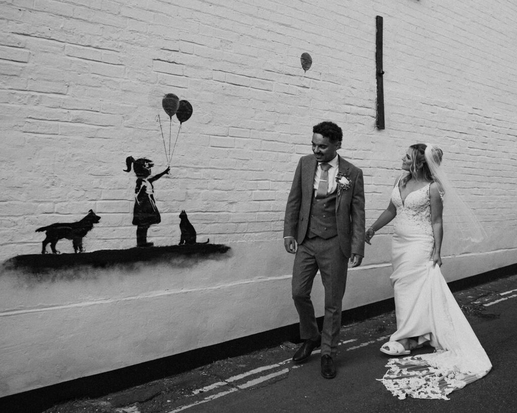 Newlyweds walking past graffiti