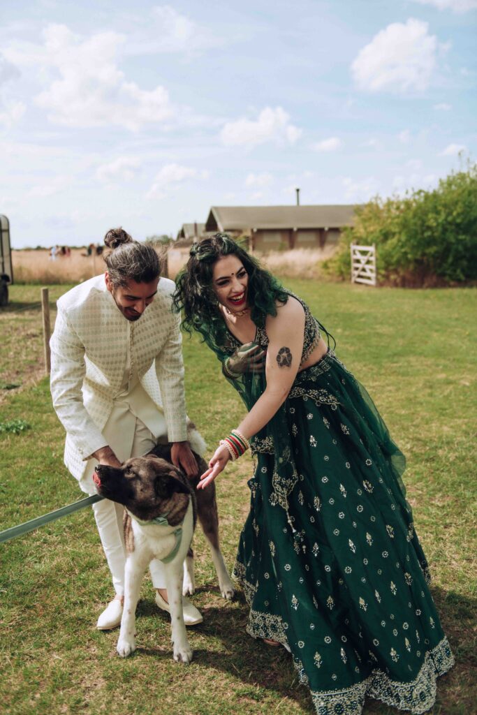 Bride and groom petting their dog