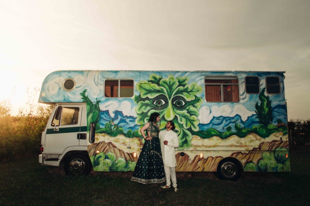 Bride and groom during sunset stood in front of caravan