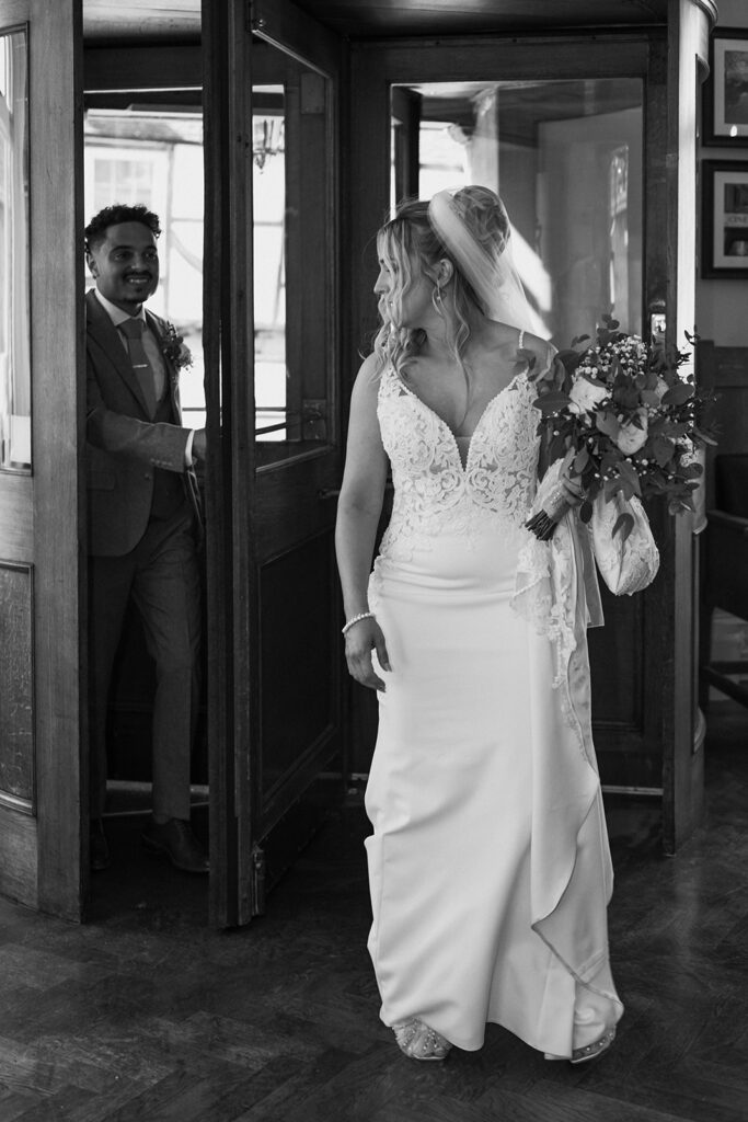 Bride and groom through revolving door of the Bell Hotel in Sandwich
