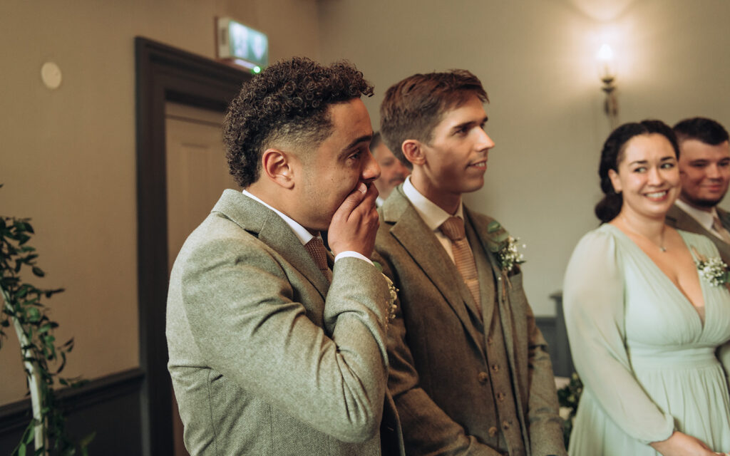 Groom with hand over mouth in shock