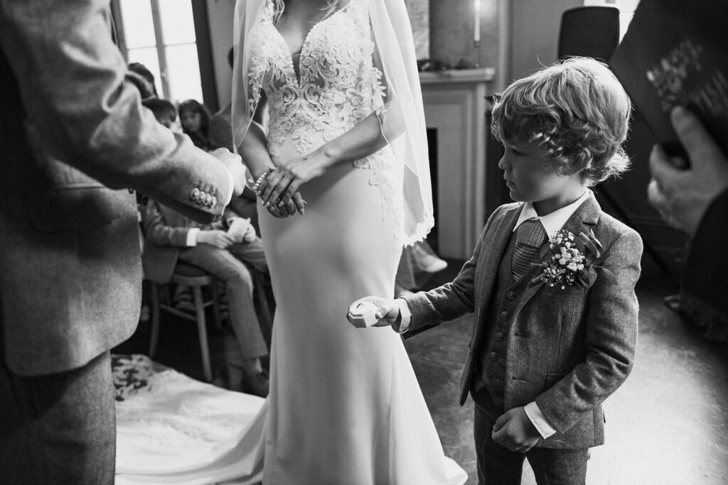 Child giving wedding rings to bride and groom