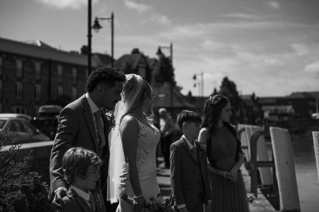 Newlyweds and their children by the quay in Sandwich