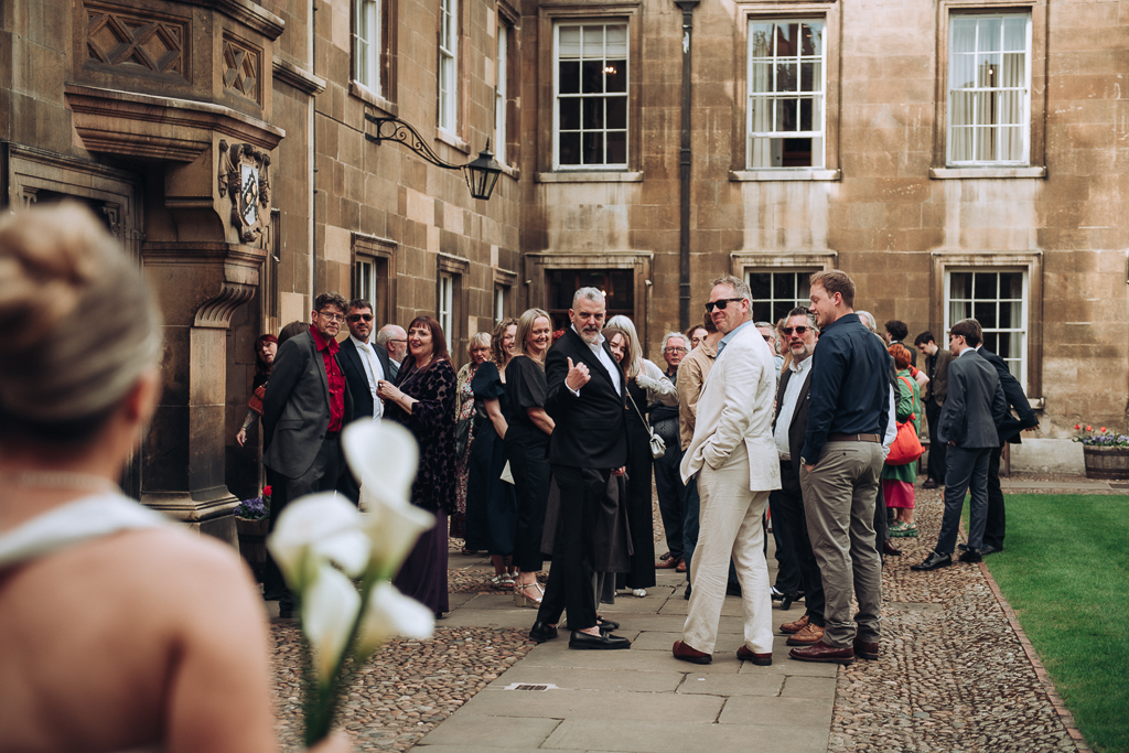 Bride being greeted by guests at gonville & caius college