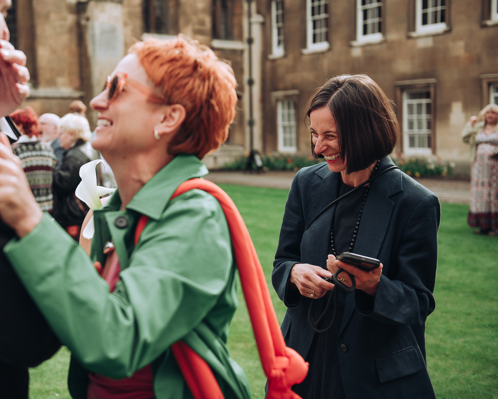 Two wedding guests laughing together