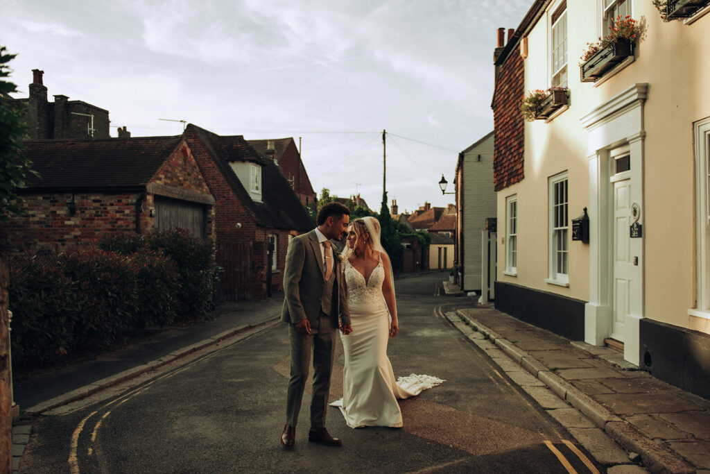 Bride and groom walking in Sandwich town
