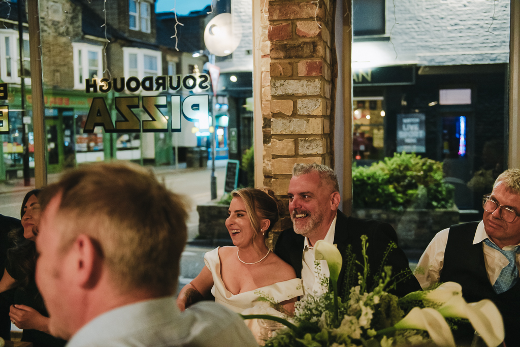 Bride and groom laughing at speech