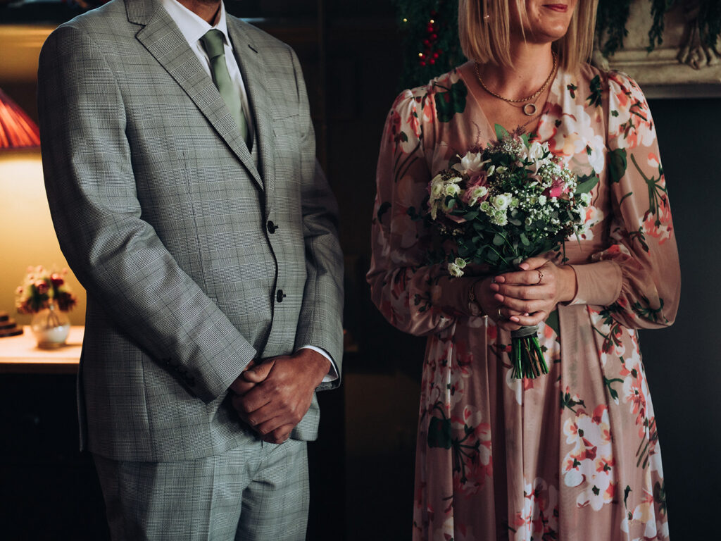 Bride holding bouquet stood next to groom