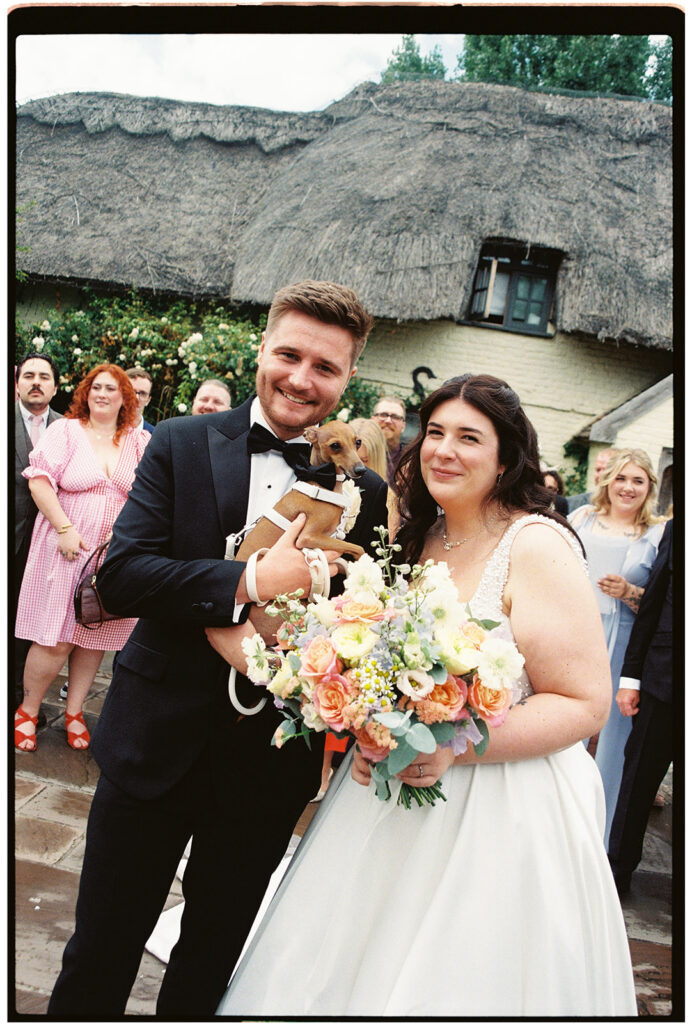 film scan of bride and groom holding their dog