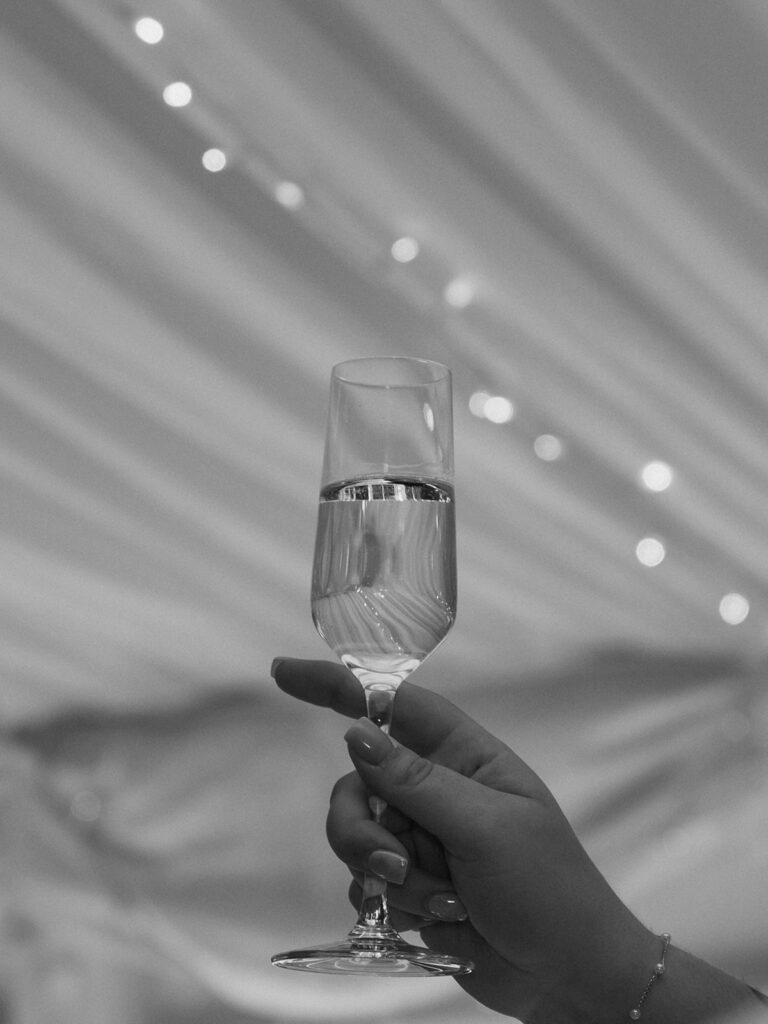 someone raising a glass of champagne at a wedding