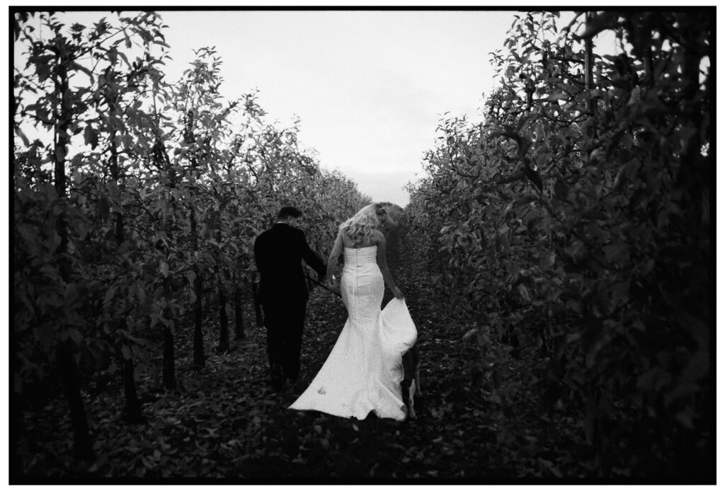 Bride and groom walking through Port Lympne with their dog
