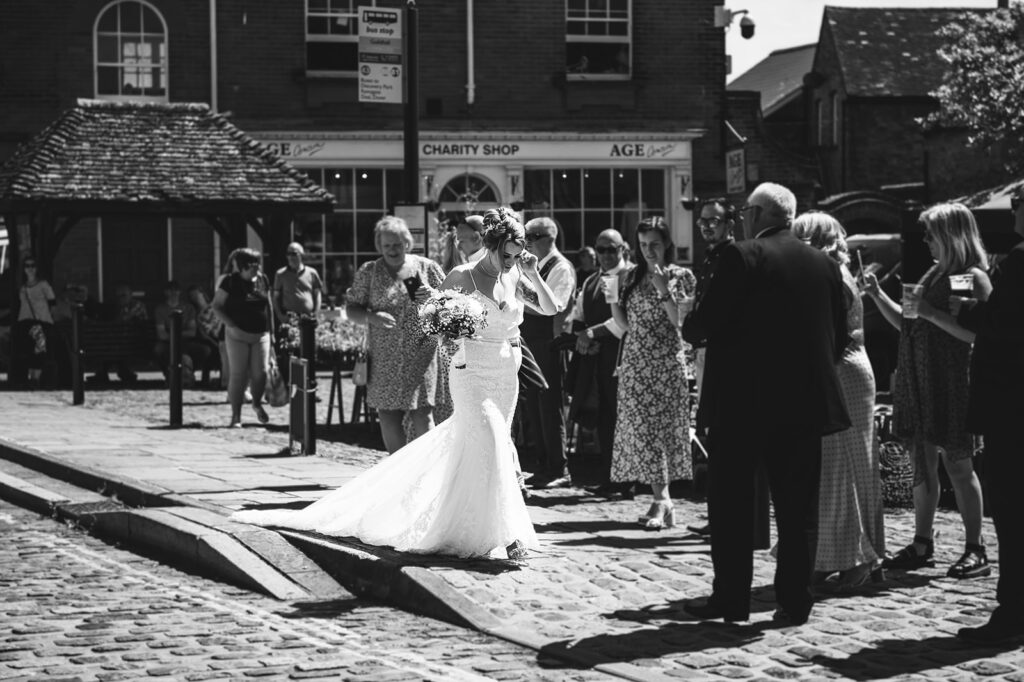 Bride walking across the market at her summer wedding in Sandwich, Kent.
