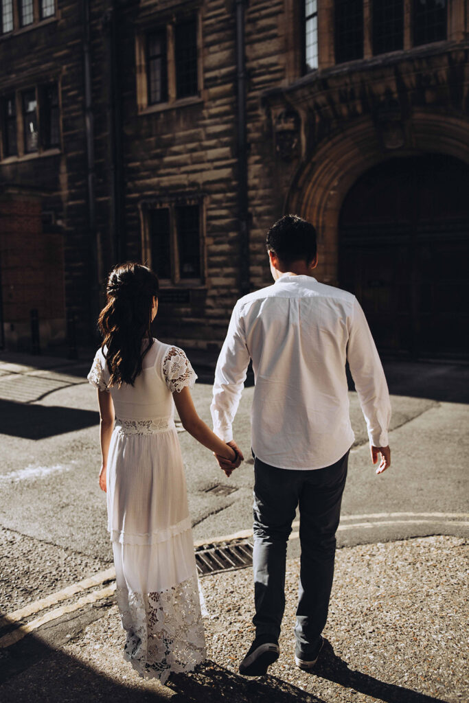 Editorial wedding photo of a couple in Cambridge walking by Kings College