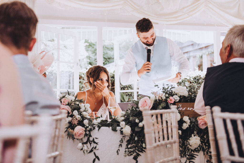 Why book documentary wedding photography for your big day? For photographs like this bride laughing at the grooms speech.