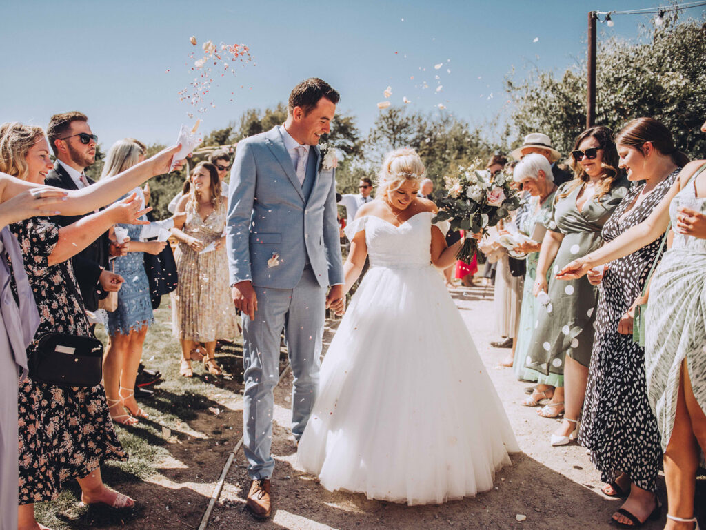 Big confetti throw on a bride and grooms summer wedding