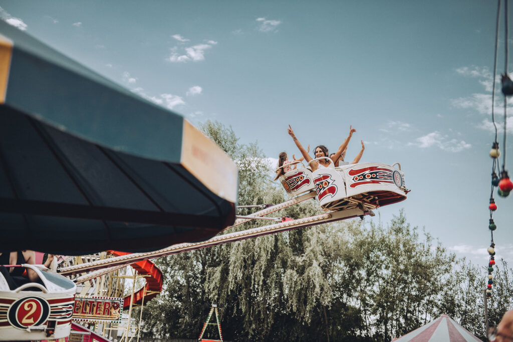 A bride celebrating on a fairground ride at Marleybrook House in Kent