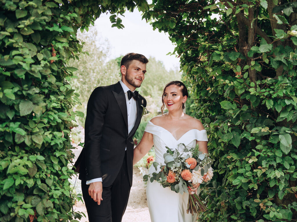 A couple walking around the gardens of their luxury wedding venue, behind the scenes of Editorial Wedding Photography: A Luxury Couple's Shoot