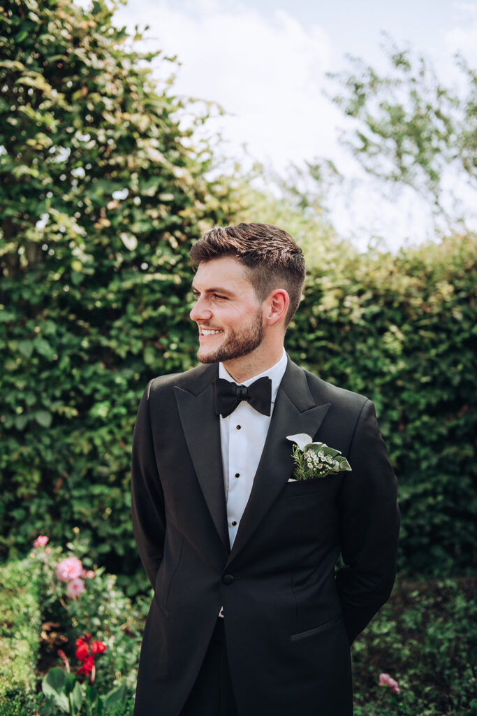 A groom smiling at his wife at his luxury wedding venue, behind the scenes of Editorial Wedding Photography: A Luxury Couple's Shoot