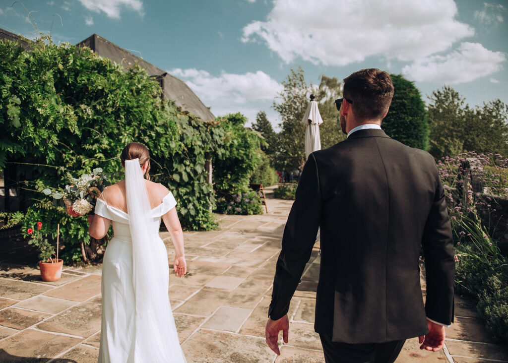 A photograph of a couple walking around the outside of their wedding venue, behind the scenes of Editorial Wedding Photography: A Luxury Couple's Shoot