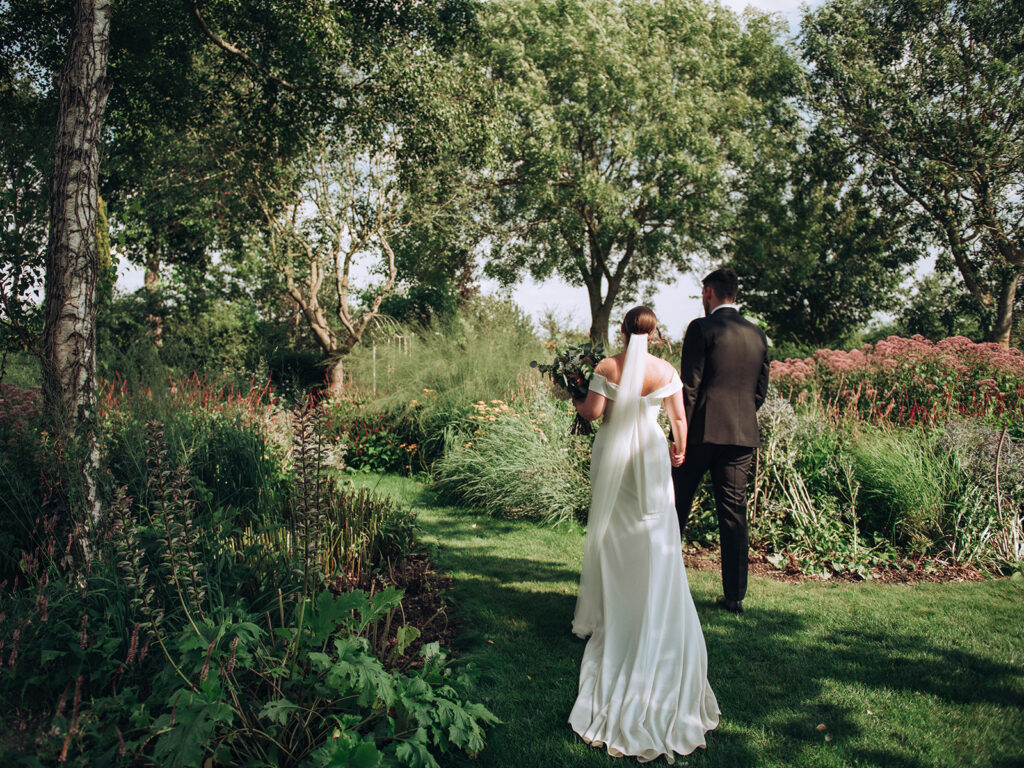 A couple exploring the gardens at their luxury wedding venue, behind the scenes of Editorial Wedding Photography: A Luxury Couple's Shoot