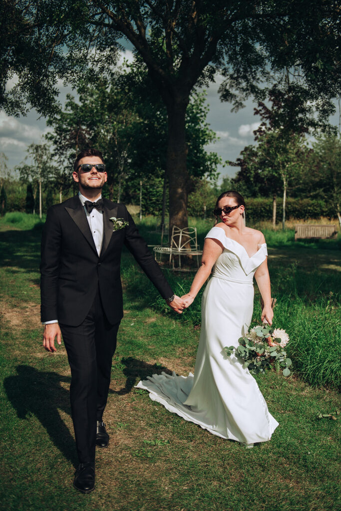 A couple pulling funny faces wearing sunglasses at their luxury wedding venue, behind the scenes of Editorial Wedding Photography: A Luxury Couple's Shoot