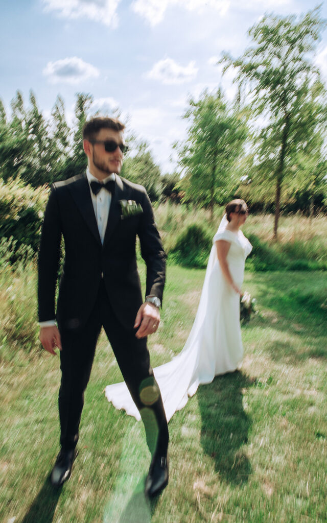 A blurry photo of a couple stood fashionably in sunglasses at their luxury wedding venue, behind the scenes of Editorial Wedding Photography: A Luxury Couple's Shoot