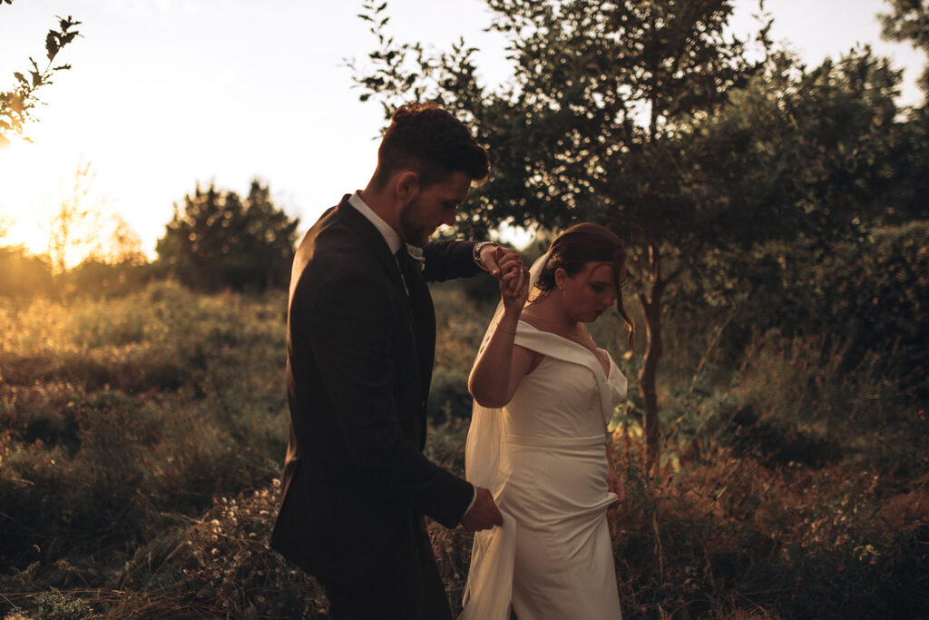 A couple twirling in wildflowers during sunset at their luxury wedding venue