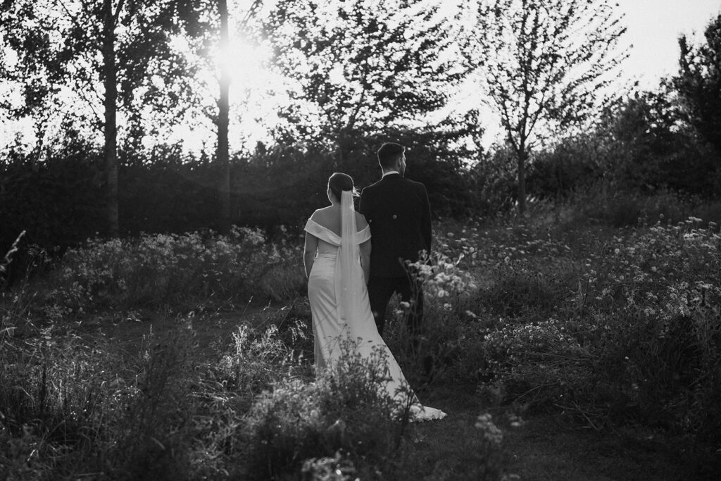 Monochrome image of a wedding couple in wildflowers