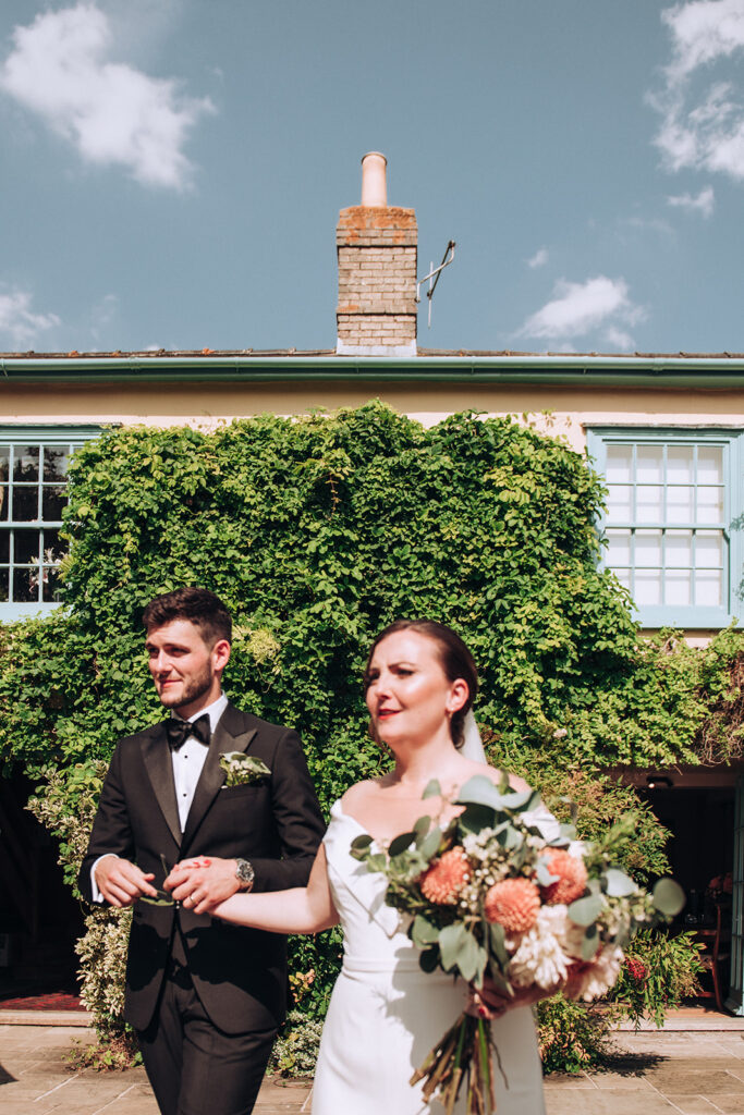 A blurry photo of a couple greeting friends at their luxury wedding venue, behind the scenes of Editorial Wedding Photography: A Luxury Couple's Shoot