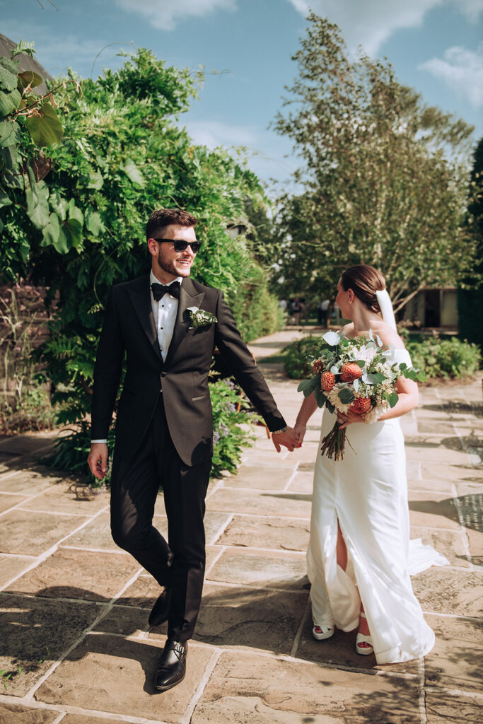 A couple walking around swinging hands at their luxury wedding venue, behind the scenes of Editorial Wedding Photography: A Luxury Couple's Shoot