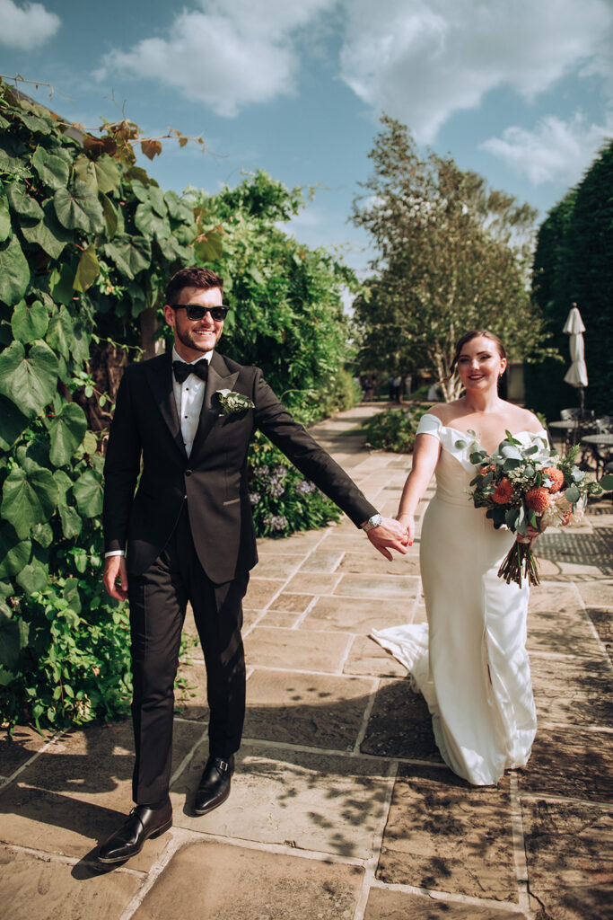 A couple walking around holding hands at their luxury wedding venue, behind the scenes of Editorial Wedding Photography: A Luxury Couple's Shoot