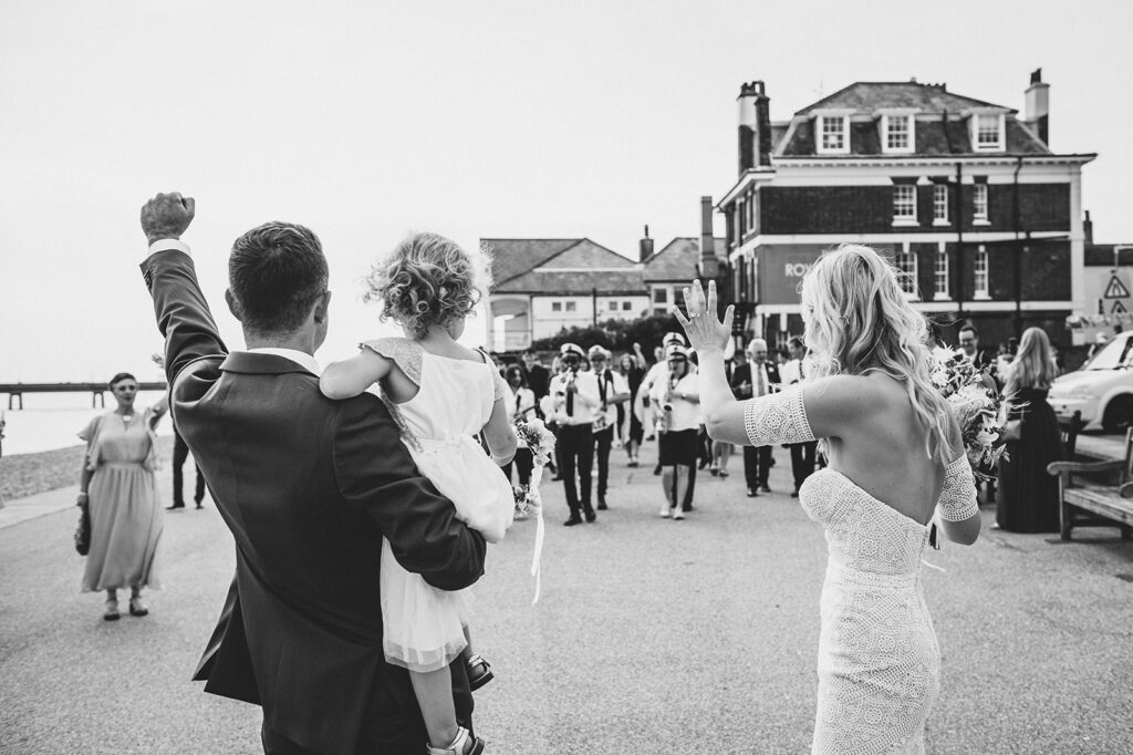 Newlywed couple and their daughter walking across the prom on the beach in Deal Kent