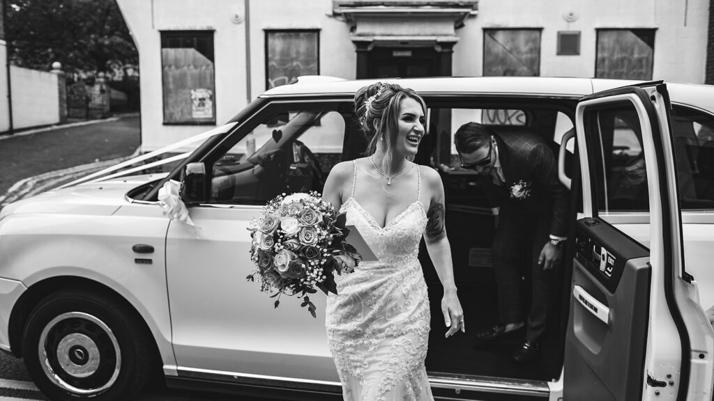 Bride arriving by taxi at her wedding in Sandwich