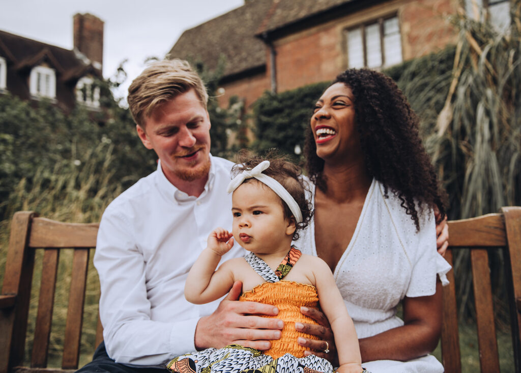 Family laughing and cuddling their daughter on a photo shoot at Westcott House in Cambridge
