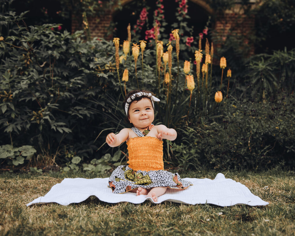 Daughter photographed dancing sat on a blanket on a family photo shoot in Cambridge.