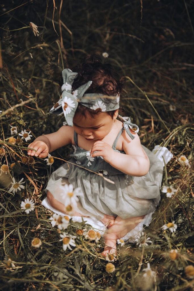 Daughter playing with flowers on a family photo shoot at Westcott House in Cambridge